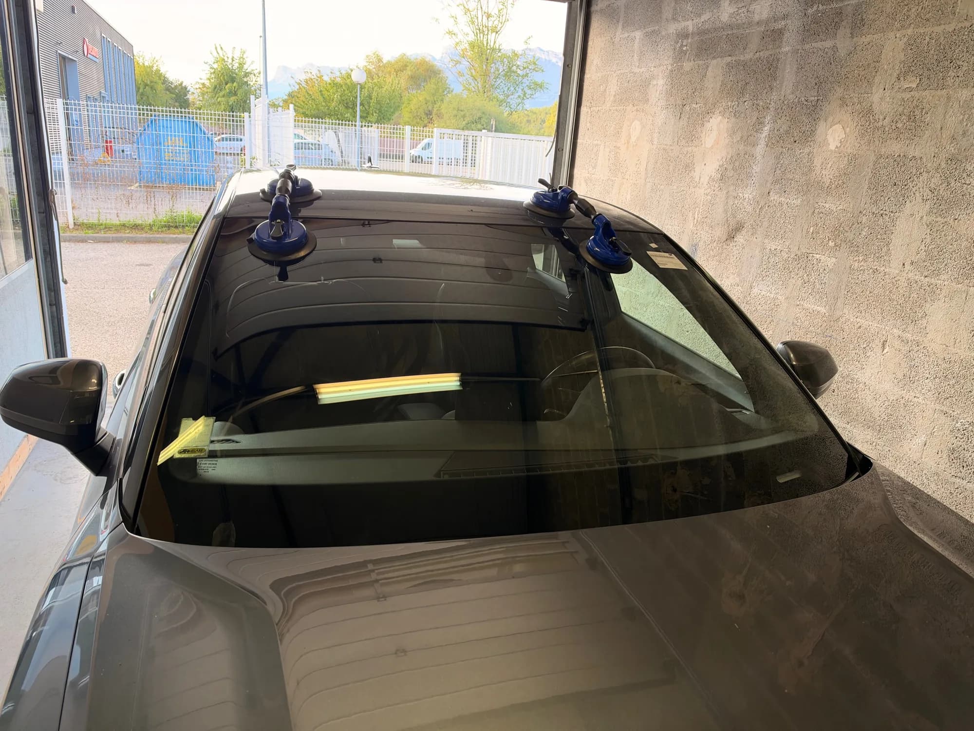 Pare-brise neuf posé aux ventouses sur une voiture